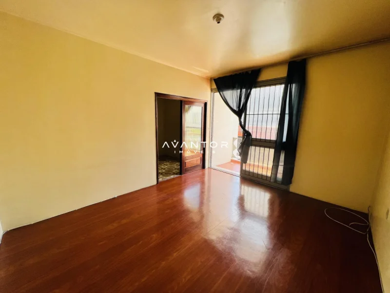 Sala com sacada e piso de madeira — Apartamento à venda e para alugar no Edifício Motta, em Centro, Santa Maria/RS