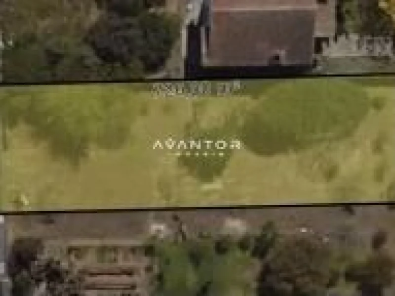 Terreno com área verde e construção ao fundo — Terreno à venda em Camobi, Santa Maria/RS