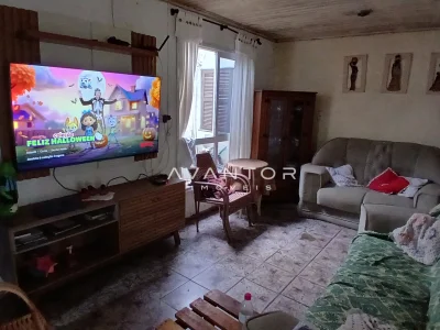 Sala de estar com sofá e televisão — Casa com 3 quartos à venda em Juscelino Kubitschek, Santa Maria/RS