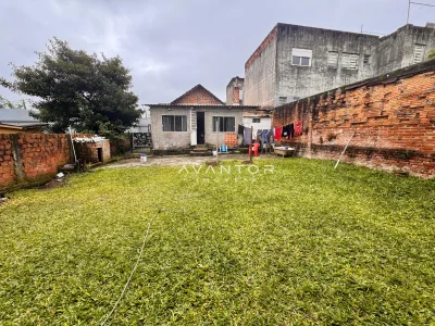 Pátio com área verde e construção ao fundo — Terreno à venda em Nossa Senhora do Rosário, Santa Maria/RS