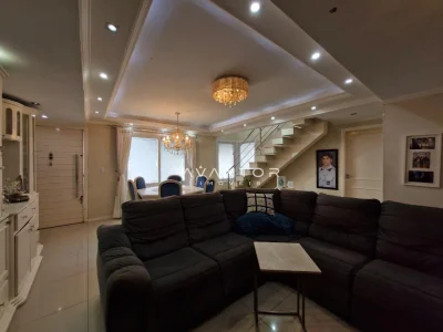 Sala de estar com sofá preto integrada à cozinha — Casa à venda no Residencial Dom Vitor III, em Camobi, Santa Maria/RS
