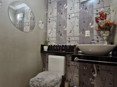 Banheiro com espelho redondo e revestimento decorado — Casa à venda no Residencial Dom Vitor III, em Camobi, Santa Maria/RS