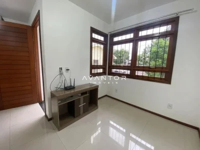 Sala com janelas de madeira e iluminação natural — Casa com 2 quartos para alugar em Camobi, Santa Maria/RS