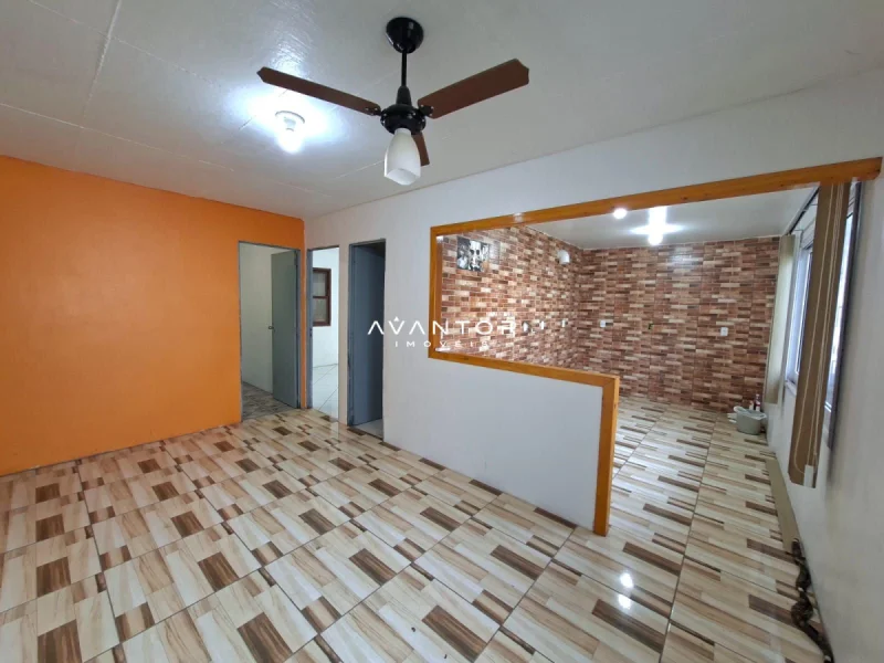Sala de estar com parede pintada de laranja — Casa com 2 quartos à venda em Tancredo Neves, Santa Maria/RS